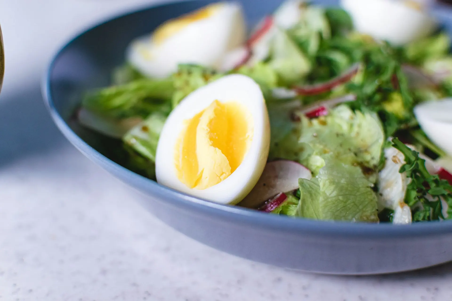 sliced tomato and green vegetable salad in white ceramic bowl